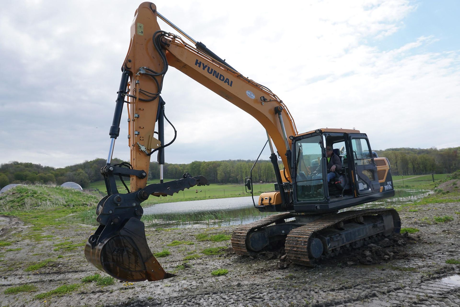 Ed demonstrates the versatility of his Hyundai HX160L excavator equipped with a Tag Bucket and thumb with a Dromone Quick Coupler