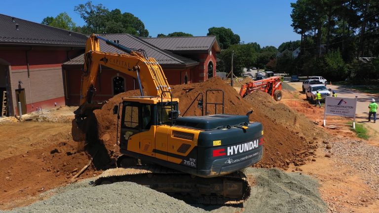 hx260l hyundai excavator working in front of a fire station